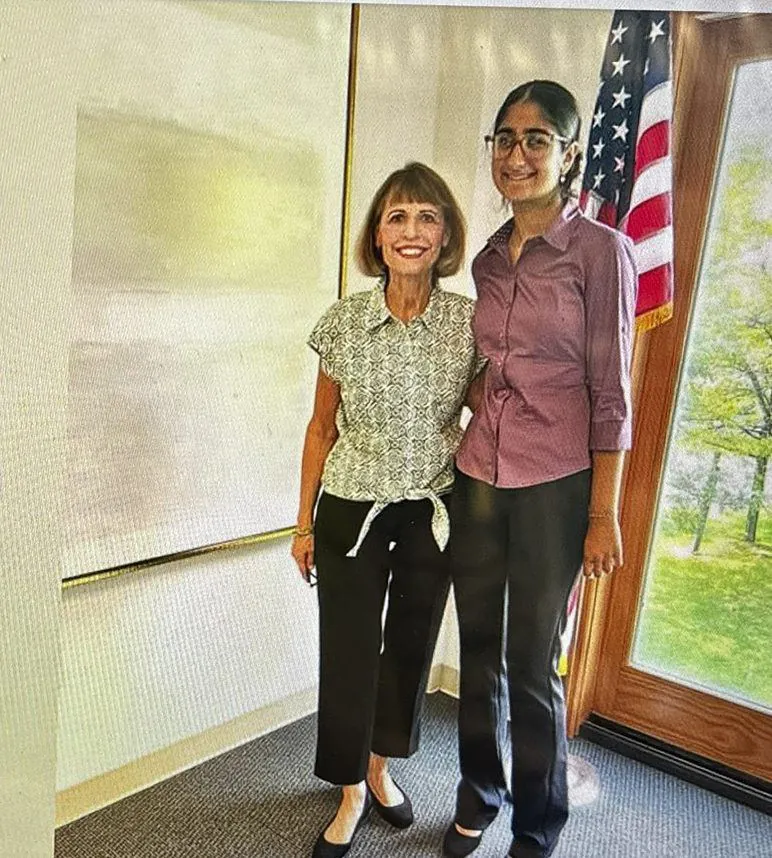 Aanya with State Representative Milou Mackenzie beside an American flag