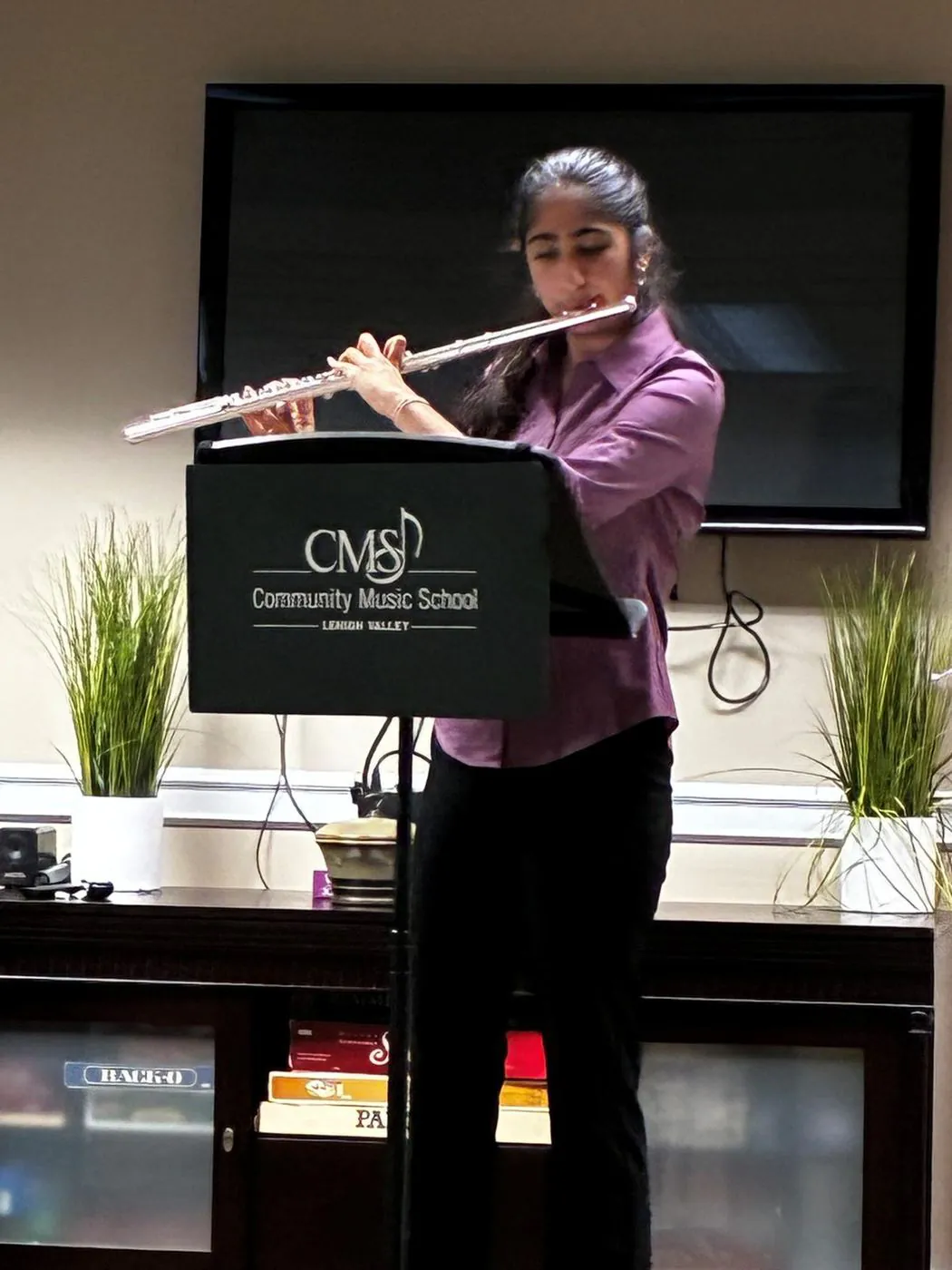 Aanya performing a flute solo at a music stand