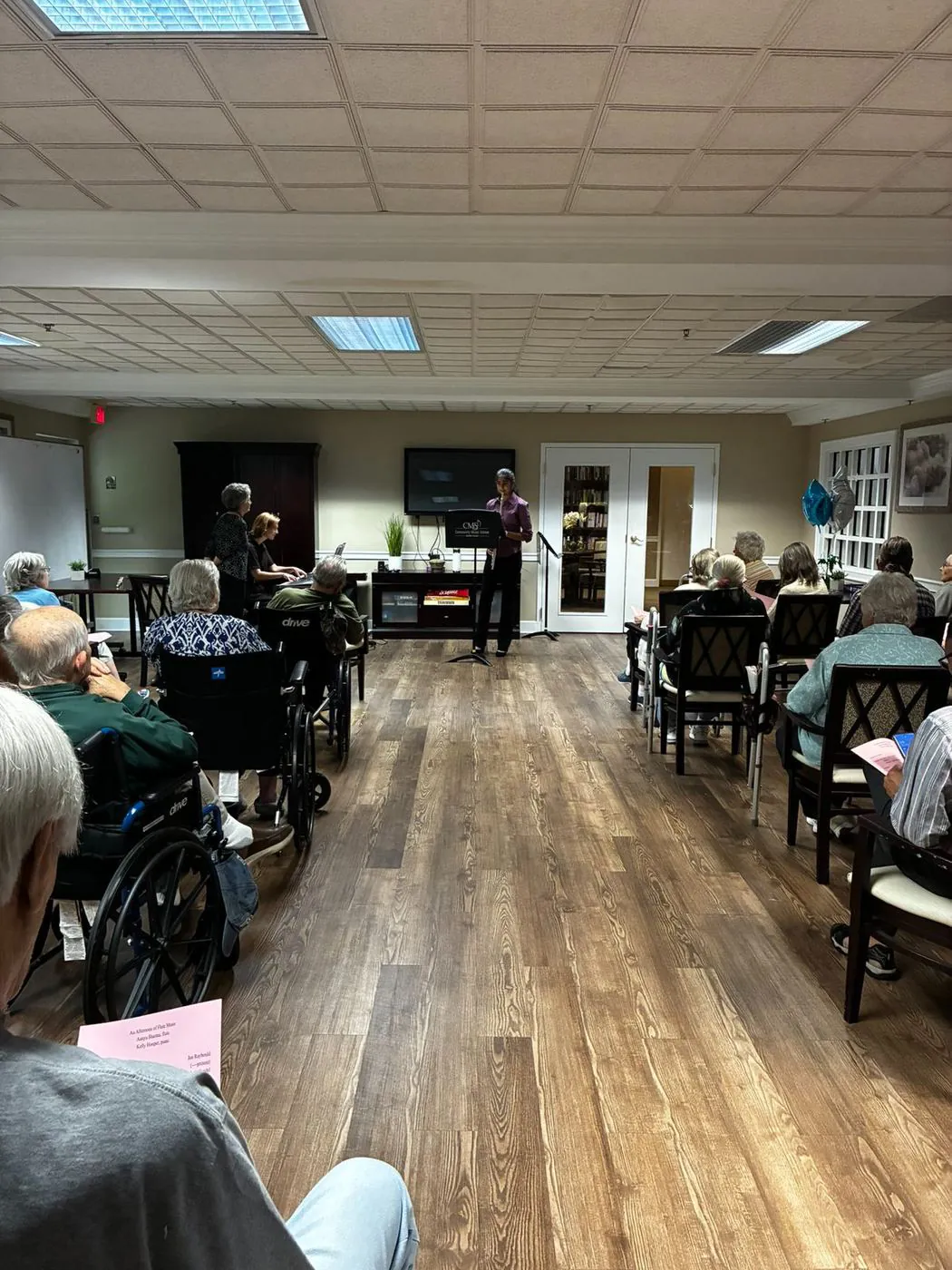 Residents of a senior living community listening to Aanya's recital